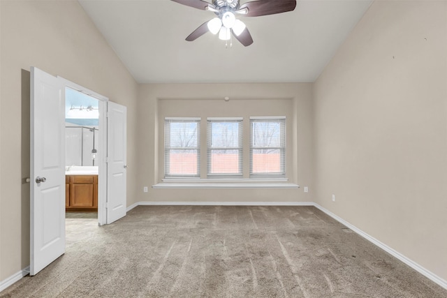 carpeted spare room with vaulted ceiling and ceiling fan