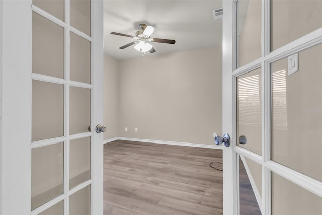 unfurnished room featuring french doors, ceiling fan, and light hardwood / wood-style flooring