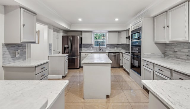 kitchen featuring gray cabinetry, a center island, light stone counters, and black appliances