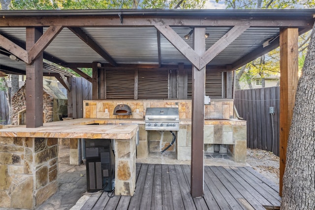 deck featuring area for grilling, an outdoor bar, and an outdoor kitchen