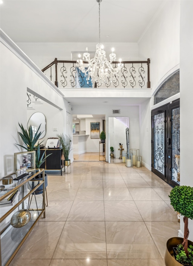 interior space featuring an inviting chandelier, ornamental molding, and french doors