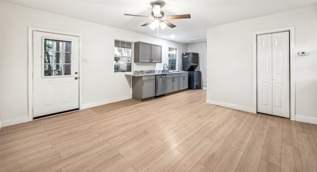 kitchen featuring sink, light wood-type flooring, gray cabinets, dishwasher, and ceiling fan