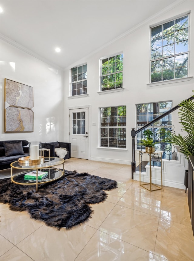 tiled living room featuring crown molding and a high ceiling