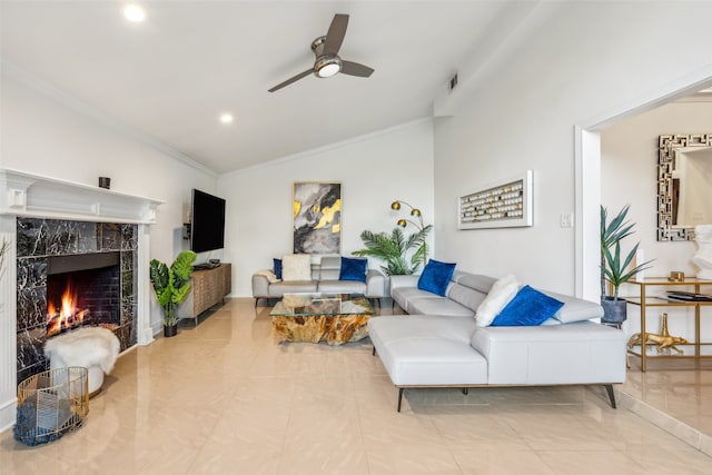 living room with lofted ceiling, crown molding, a premium fireplace, ceiling fan, and light tile patterned flooring