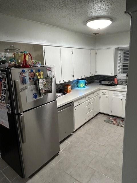 kitchen with sink, white cabinets, stainless steel appliances, and a textured ceiling