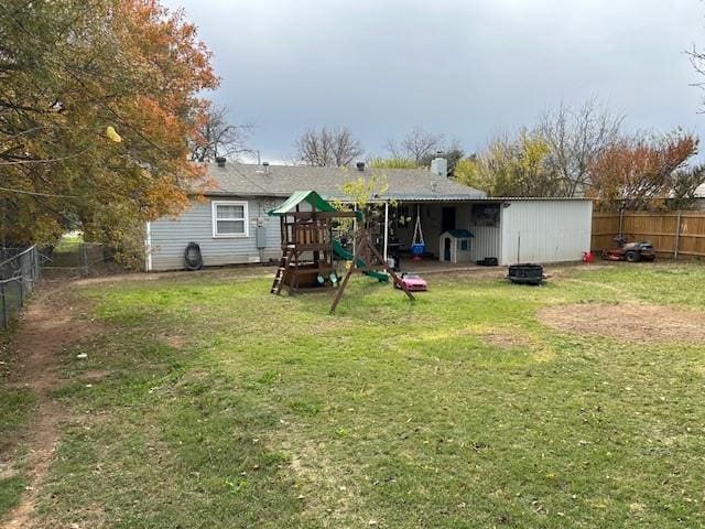 back of property featuring a lawn and a playground