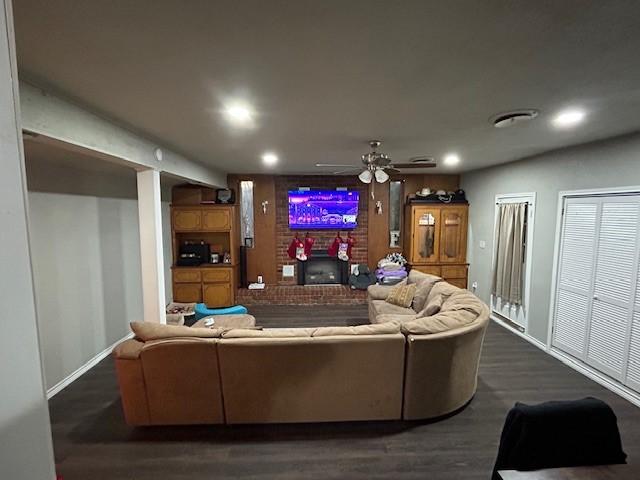 living room with ceiling fan and dark hardwood / wood-style flooring