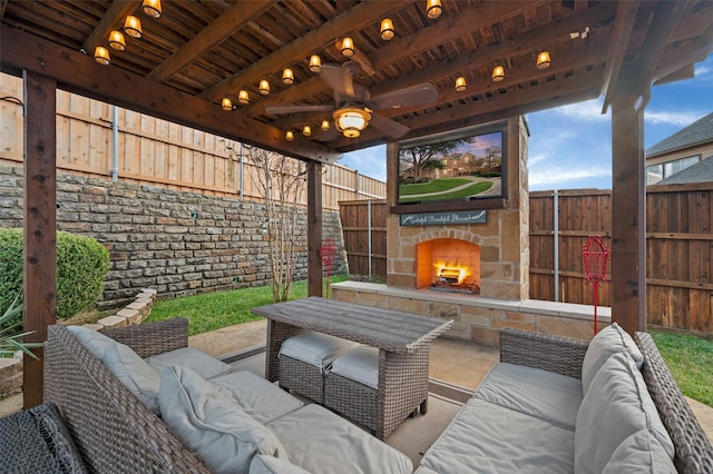 view of patio with an outdoor living space with a fireplace and ceiling fan