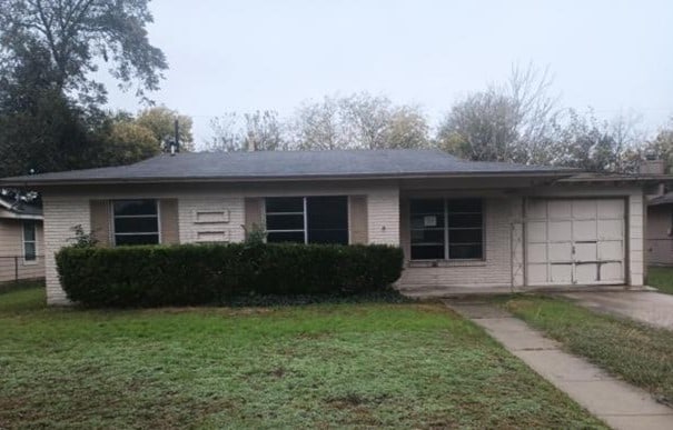 single story home with a garage and a front yard