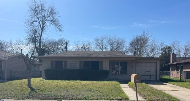 single story home with driveway, an attached garage, a front yard, and fence