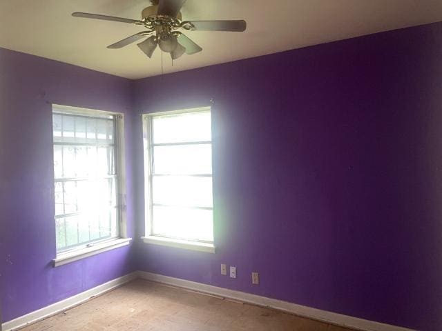 empty room featuring a ceiling fan and baseboards