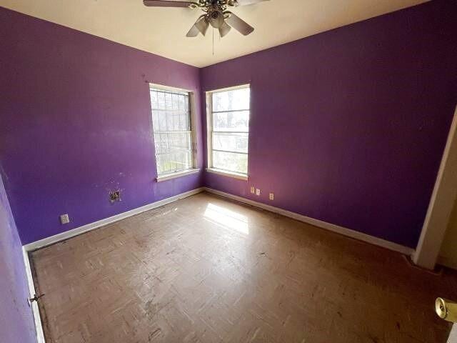 spare room featuring baseboards and ceiling fan