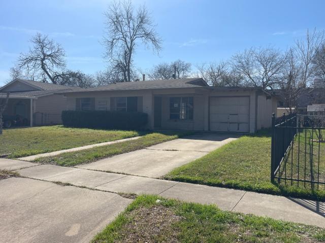 ranch-style house featuring stucco siding, fence, concrete driveway, an attached garage, and a front yard