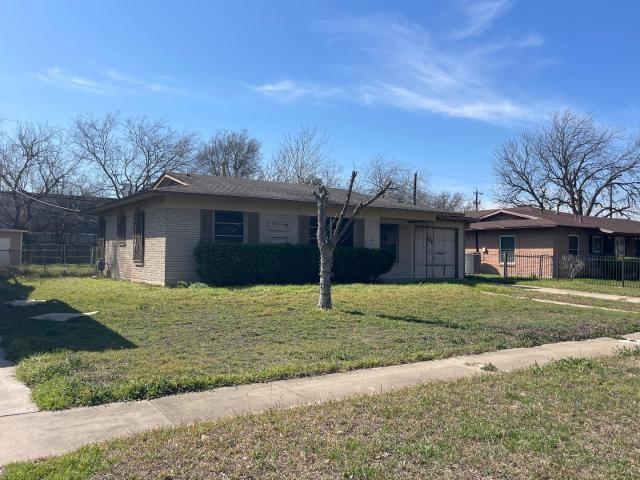 single story home featuring a front yard, fence, and brick siding