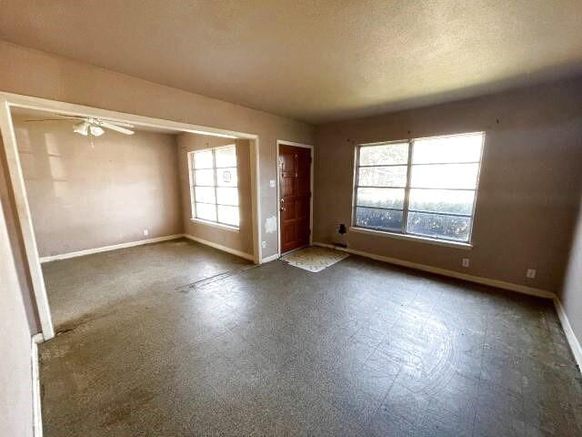 spare room with a wealth of natural light, baseboards, and a textured ceiling