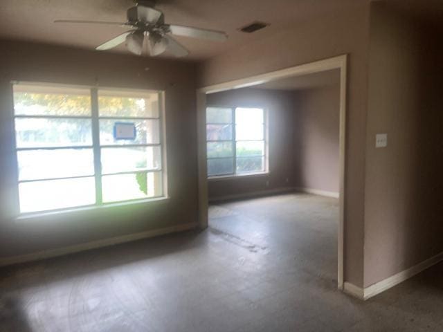 spare room with visible vents, ceiling fan, and baseboards