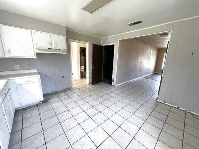 kitchen with light tile patterned floors, visible vents, white cabinets, and light countertops