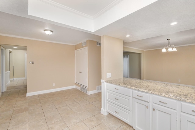 kitchen with light stone counters, ornamental molding, decorative light fixtures, a chandelier, and white cabinetry