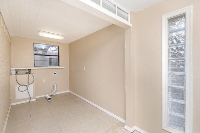 washroom with hookup for a washing machine, light tile patterned floors, and hookup for an electric dryer