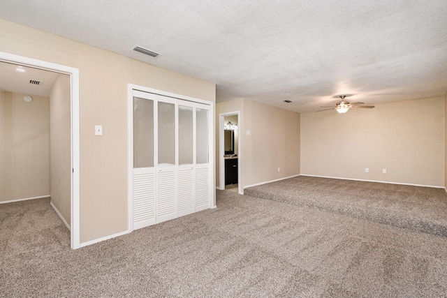 interior space with a textured ceiling and ceiling fan