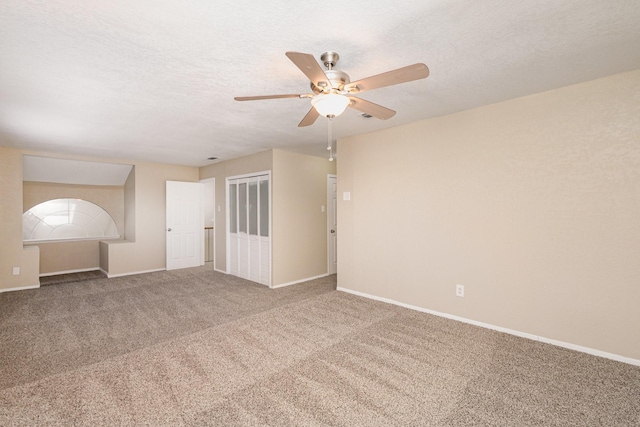 carpeted empty room featuring a textured ceiling and ceiling fan