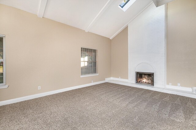 unfurnished living room featuring carpet flooring, a brick fireplace, a healthy amount of sunlight, and vaulted ceiling with skylight