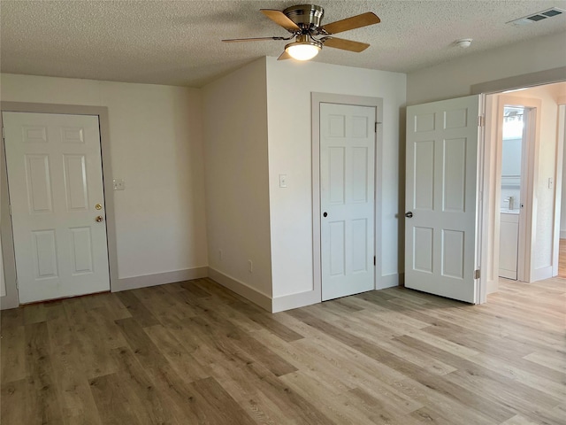 unfurnished bedroom featuring light wood-type flooring, a textured ceiling, and ceiling fan