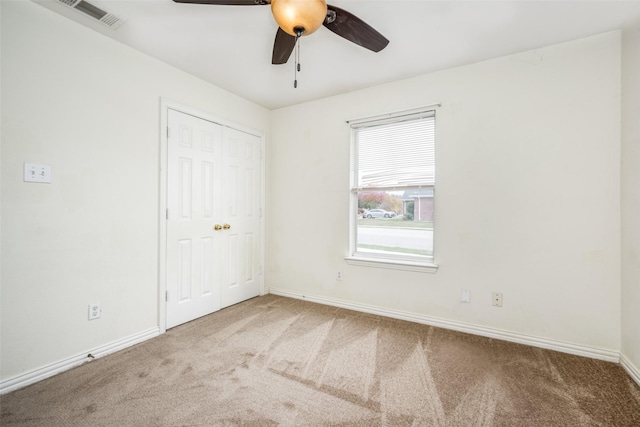 empty room featuring carpet flooring and ceiling fan