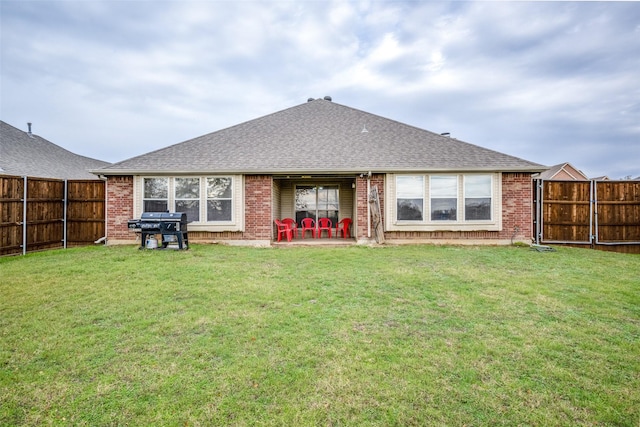 rear view of house with a lawn and a patio area