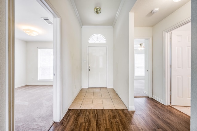 foyer entrance with crown molding, light hardwood / wood-style flooring, and ceiling fan