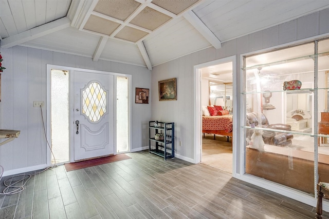 foyer featuring hardwood / wood-style flooring, vaulted ceiling with beams, wood walls, and wooden ceiling