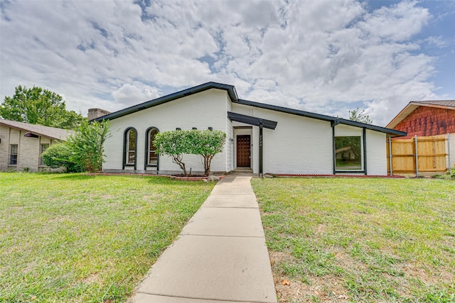 single story home featuring a front lawn