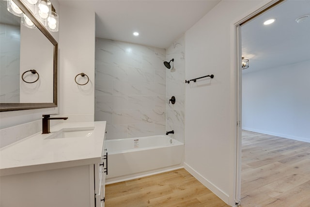 bathroom with vanity, wood-type flooring, and tiled shower / bath combo