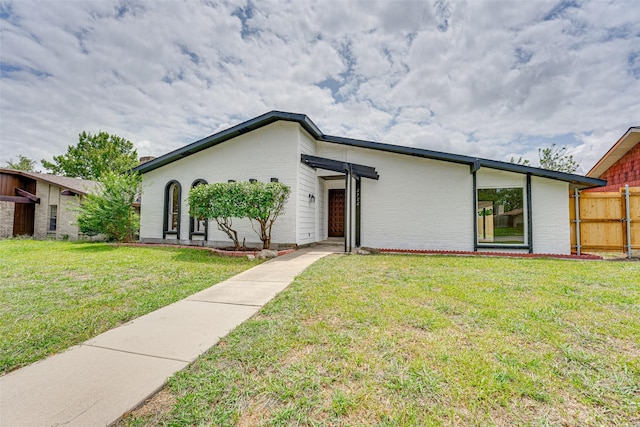 ranch-style home featuring a front lawn