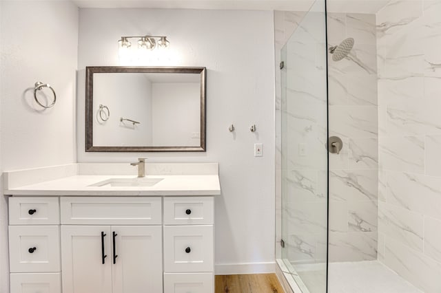 bathroom featuring vanity, wood-type flooring, and tiled shower