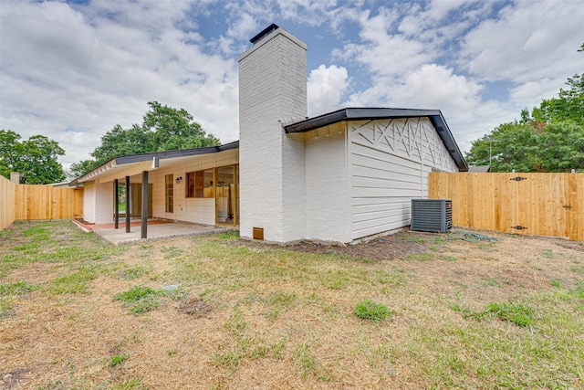 back of house with a lawn, a patio area, and cooling unit