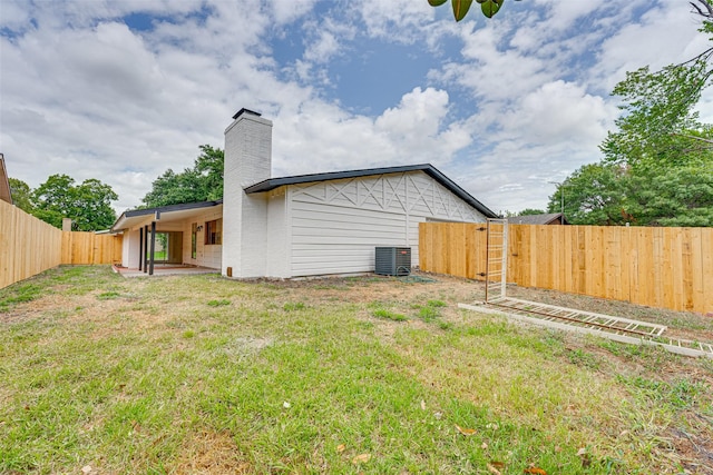 back of property featuring cooling unit, a patio area, and a lawn