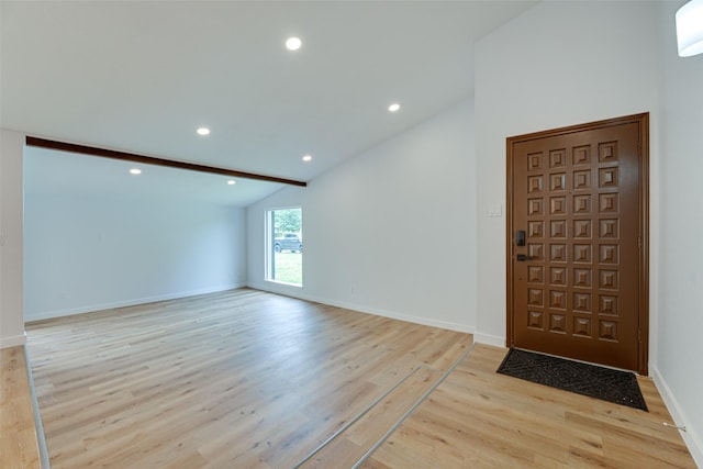 entryway featuring vaulted ceiling with beams and light wood-type flooring