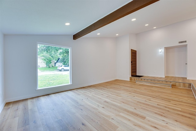 empty room featuring vaulted ceiling with beams and light wood-type flooring