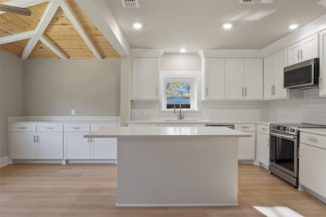 kitchen with white cabinets, a center island, and appliances with stainless steel finishes