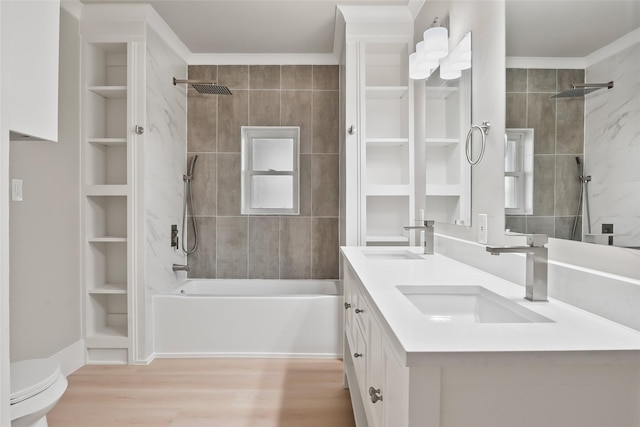 full bathroom with vanity, hardwood / wood-style flooring, tiled shower / bath combo, built in shelves, and toilet