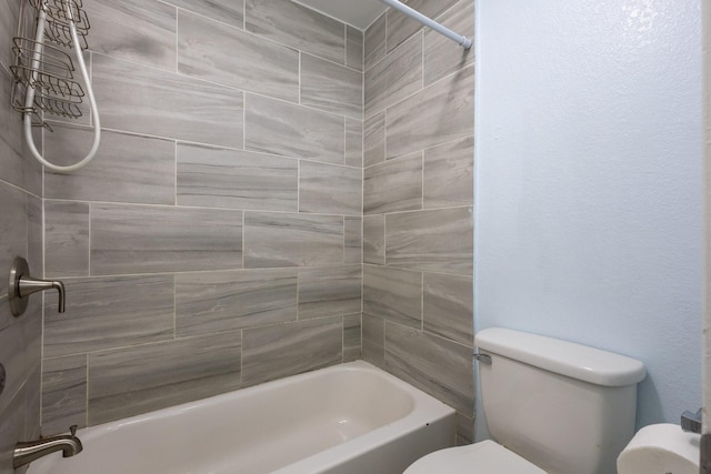 bathroom featuring tiled shower / bath combo and toilet