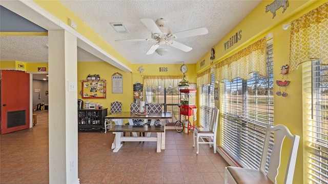 interior space featuring tile patterned floors, ceiling fan, and a textured ceiling