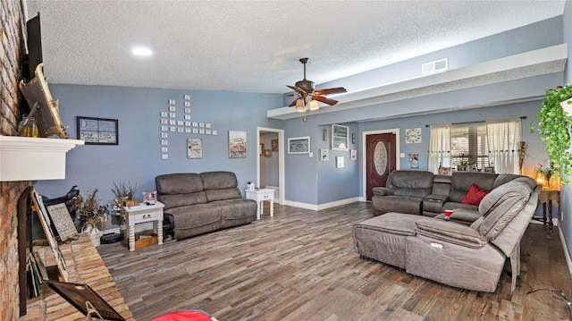 living room featuring a textured ceiling, ceiling fan, hardwood / wood-style floors, and vaulted ceiling