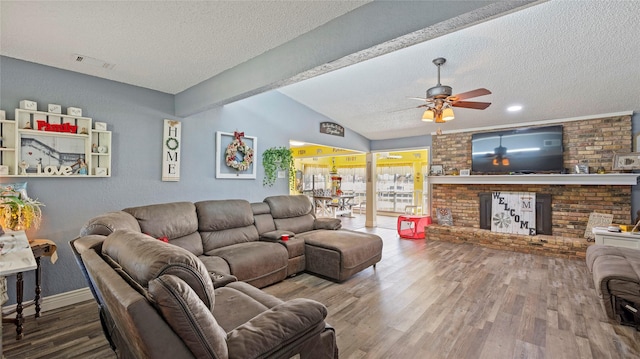 living room with ceiling fan, hardwood / wood-style floors, lofted ceiling with beams, and a textured ceiling