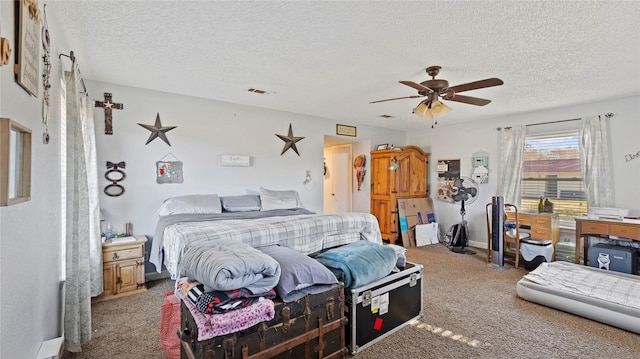 carpeted bedroom featuring ceiling fan and a textured ceiling