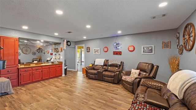 living room with light hardwood / wood-style floors and a textured ceiling