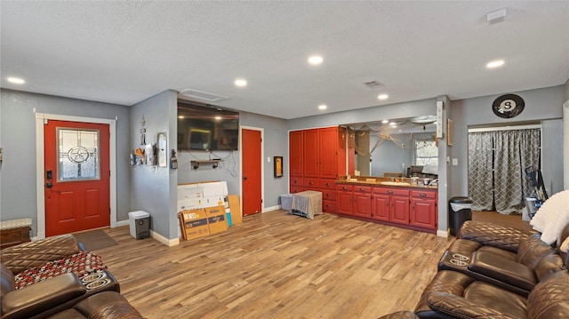 living room with light wood-type flooring and a textured ceiling