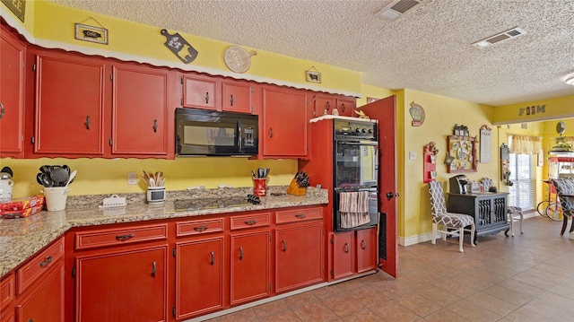 kitchen with light stone countertops, light tile patterned floors, a textured ceiling, and black appliances