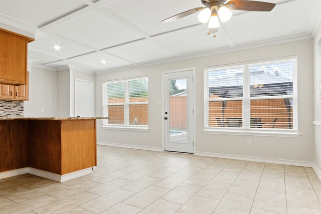 kitchen featuring light tile patterned flooring, coffered ceiling, tasteful backsplash, ceiling fan, and light stone countertops